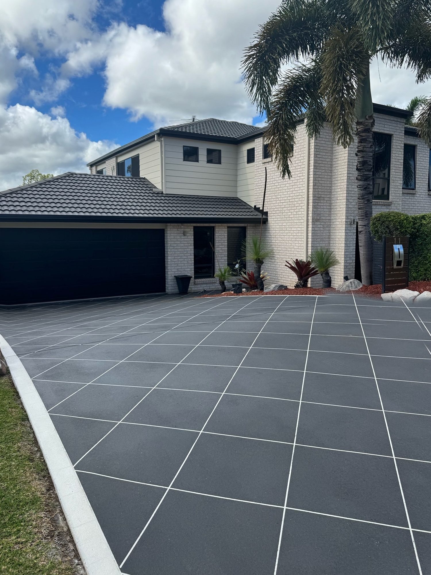 The same driveway resurfaced in Midnight Blue Spraycrete with a white stencil grid